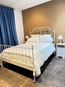 a bedroom with a white bed and a blue curtain at Hotel Restaurante Sonsoles in Ávila