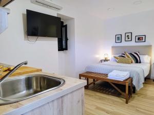 a kitchen with a sink and a bed in a room at Alojamiento cruceiro Arans in La Cañiza