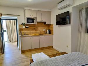 a small kitchen with white cabinets and a microwave at Alojamiento cruceiro Arans in La Cañiza