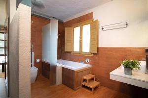a bathroom with a sink and a toilet and a window at The Pines Hotel in Culla