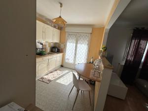 a kitchen with white cabinets and a table and chairs at Made 1 in Le Mans