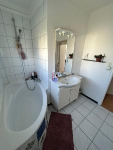 a white bathroom with a tub and a sink at Made 1 in Le Mans