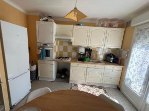 a small kitchen with white cabinets and a table at Made 1 in Le Mans