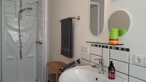 a white bathroom with a sink and a shower at Ferienwohnung Auguste in Munster +26 photos