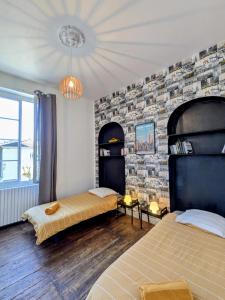 two beds in a room with a brick wall at White Chapel in Condom