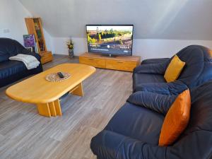 a living room with a couch and a table and a tv at Ferienwohnung Auguste in Munster