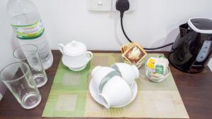 a table with plates and cups and a coffee maker at Green leaf Villa in Dambulla