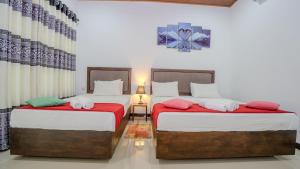 a bedroom with two beds with red and white sheets at Green leaf Villa in Dambulla +43 photos