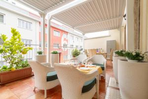 a restaurant with white chairs and tables on a balcony at Dimora al Naviglio in Milan