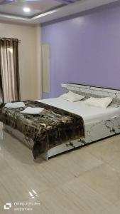 a bedroom with two beds in a room with purple walls at Saisha Palace Hotel, Ganpatipule in Ganpatipule +29 photos
