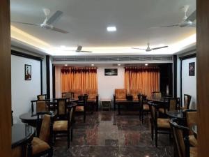 a dining room with tables and chairs in a restaurant at Ango Plaza Hotel in Kovilpatti +17 photos