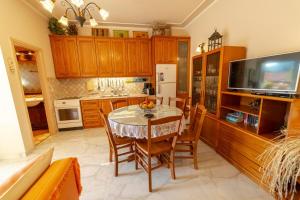a kitchen with a table and chairs and a television at 2-BR Apartment by the Sea in Paramonas