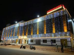 a large building is lit up at night at Ango Plaza Hotel in Kovilpatti