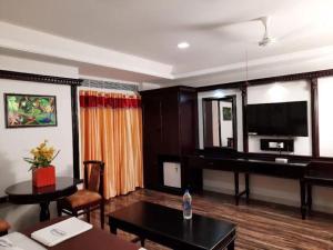 a living room with a table and a piano at Ango Plaza Hotel in Kovilpatti