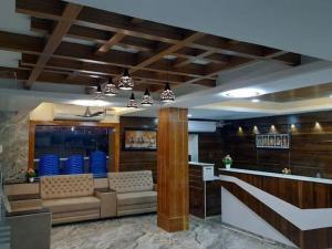 a restaurant with a waiting room with couches and a bar at Ango Plaza Hotel in Kovilpatti