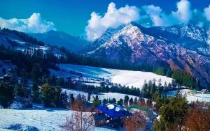 a view of a snowy mountain with a blue tent at Sunset Homestay in Sainj