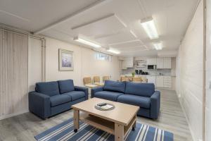 a living room with two blue couches and a table at Jääskän Loma, Kojolapark Luiska-hostelli in Voltti