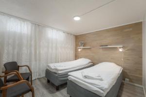 a hospital room with two beds and a chair at Jääskän Loma, Kojolapark Luiska-hostelli in Voltti