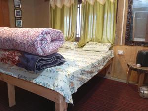 a bedroom with a bed with pillows on it at Sunset Homestay in Sainj