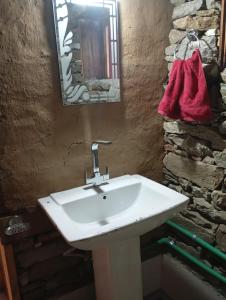 a bathroom with a white sink and a mirror at Sunset Homestay in Sainj