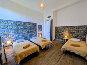 a room with three beds and a wall with plants at White Chapel in Condom +15 photos