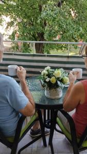 two people sitting at a table with cups of coffee at Fehérvár Cappuccino apartman City center, AC, Easy Parking in Székesfehérvár