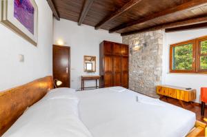 a bedroom with a large bed and a stone wall at Brela Seaview Apartment with Swimming Pool & Parking in Brela +41 photos