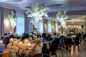 a banquet room with tables and chairs with chandeliers at Royal Park Hotel & Spa in Mielno +41 photos