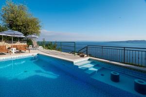 a swimming pool with a view of the ocean at Brela Seaview Apartment with Swimming Pool & Parking in Brela