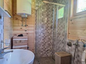 a bathroom with a shower and a white sink at Riverland Cottage 2 in Kolašin