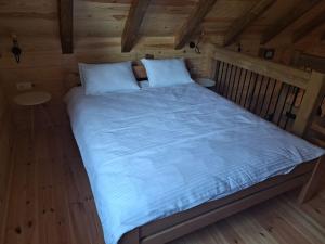 a large bed in a room with a wooden ceiling at Riverland Cottage 2 in Kolašin