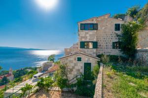 a house on a hill next to the ocean at Brela Seaview Apartment with Swimming Pool & Parking in Brela