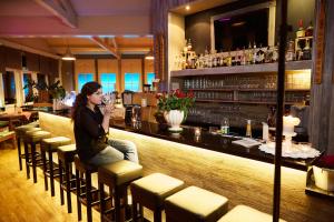 a woman sitting at a bar in a restaurant at Pindeck in Bad Oldesloe