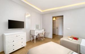 a bedroom with a bed and a desk with a tv at Begovina in Marmaris
