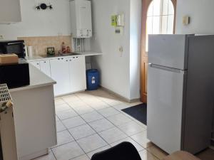 a kitchen with white cabinets and a refrigerator at Le lumineux-T2 calme-animaux acceptés-place auto in Saint-Gaudens