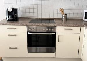 a kitchen with a stove and white cabinets at Private Apartment with Terrace and Parking in Dortmund