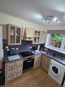 a kitchen with a sink and a washing machine at Ardgay in Fort Augustus