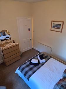 a bedroom with a bed and a dresser and a mirror at Ardgay in Fort Augustus