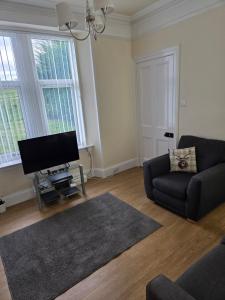 a living room with a couch and a flat screen tv at Ardgay in Fort Augustus