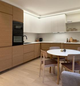 a kitchen with a table and a kitchen with white cabinets at Odda Gangdal Apartments in Odda