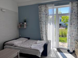 a bedroom with a bed and a large window at SKiPER Dębki in Dębki