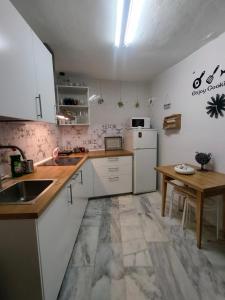 a kitchen with white appliances and a wooden table at Casa Fuente del Caño in Casarabonela
