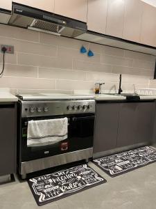 a kitchen with a stove and towels on the floor at Lex Place Syokimau in Syokimau