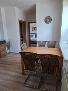 a dining room table with chairs and a clock on the wall at Ferienwohnung Wagner in Stegersbach