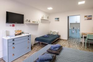 a room with a bedroom with a bed and a tv at Mirabella apartman in Csopak