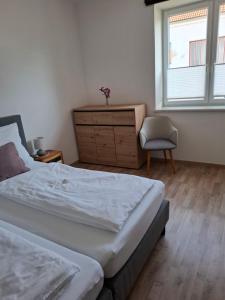 a bedroom with two beds and a dresser and a window at Ferienwohnung Wagner in Stegersbach