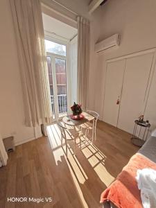 a living room with a table and a window at La Dimora di Tuya Superior in Naples +15 photos