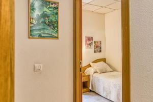 a small bedroom with a bed and a mirror at Hostal La Barretina in Figueres