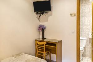 a room with a desk with a television and a chair at Hostal La Barretina in Figueres