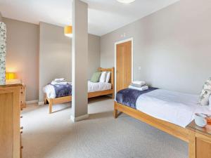 a bedroom with two beds and a mirror at 4 Bed in Talsarnau oc-96164 in Talsarnau